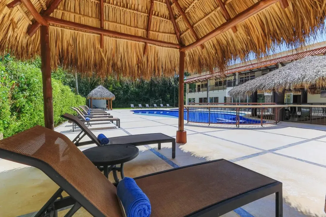 Covered palapa lounge beside the pool at a private retreat villa near Jaco, Costa Rica