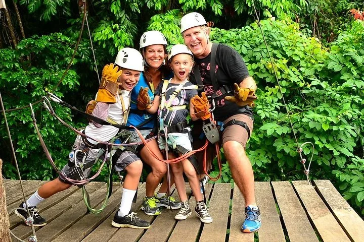 Family wearing zipline gear on a canopy platform in Costa Rica