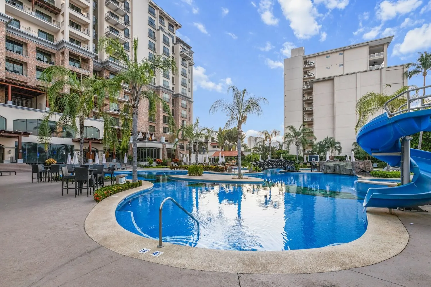 Croc's Resort pool with a waterslide beside The Palms condominiums