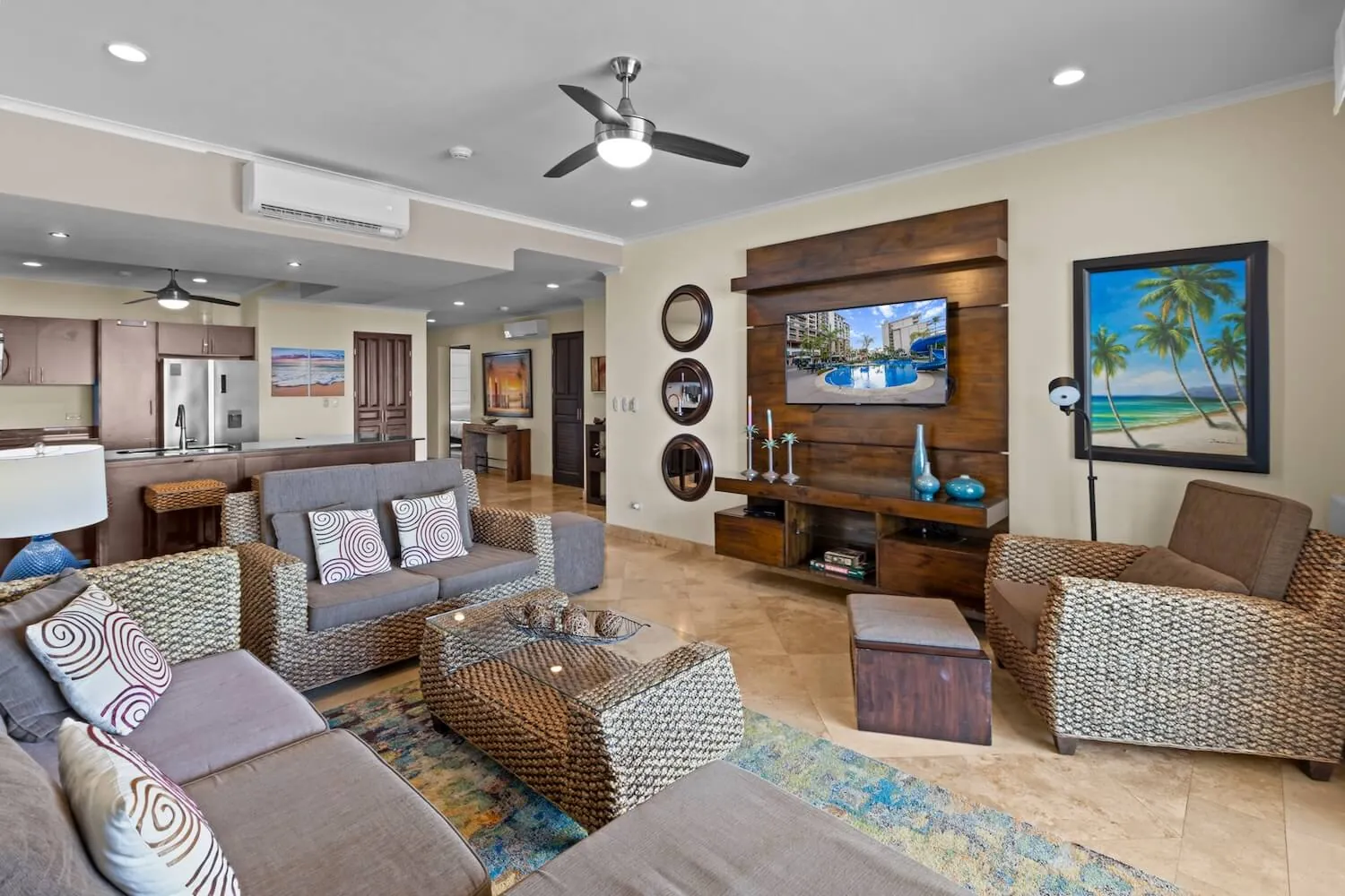 Living room of The Palms 1002 with wicker sofas and wall TV