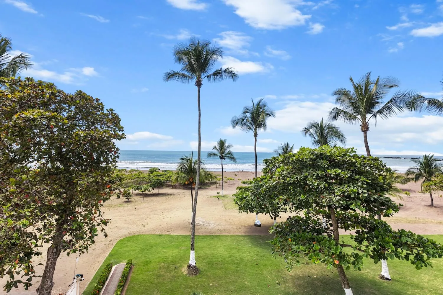 Palms, lawn and Jaco Beach seen from the third-floor balcony