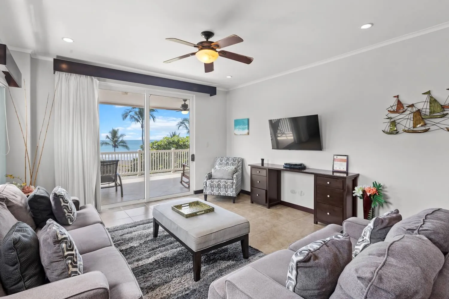 Living room at The Palms 304 with grey sofas and ocean view