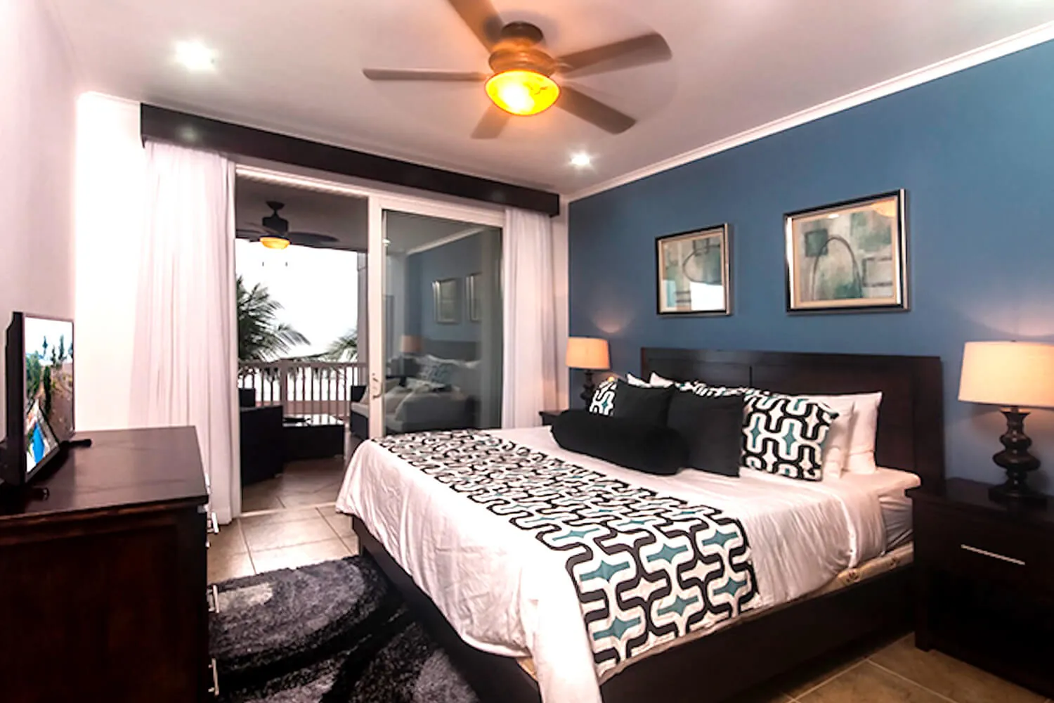 Primary bedroom at The Palms 402 with king bed and balcony doors