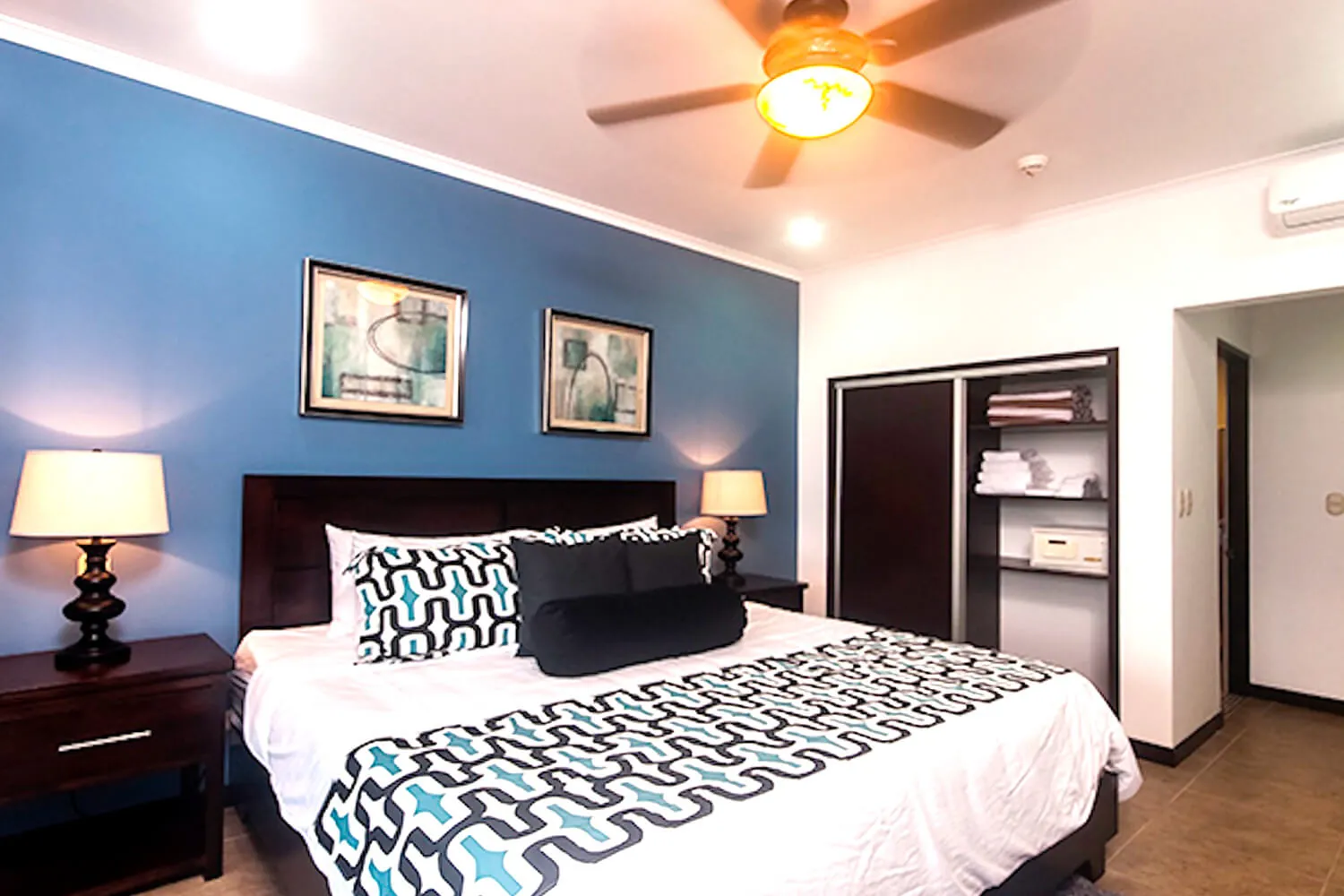 King bed with patterned throw at The Palms 402