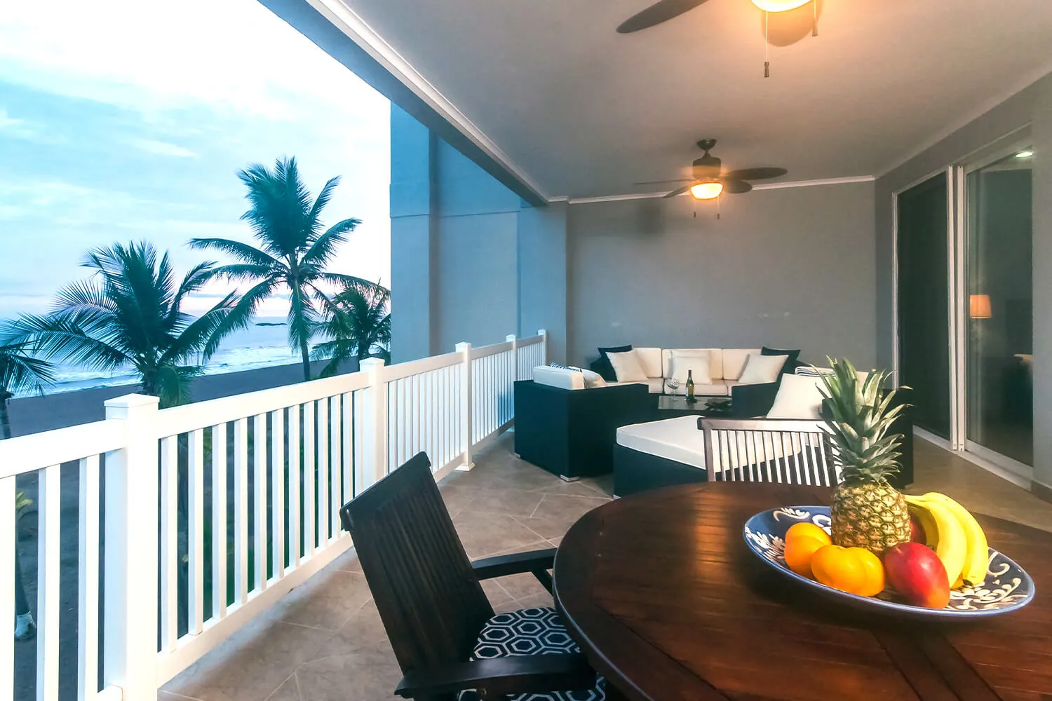 Balcony of The Palms 402 with a round table, fruit bowl and ocean view