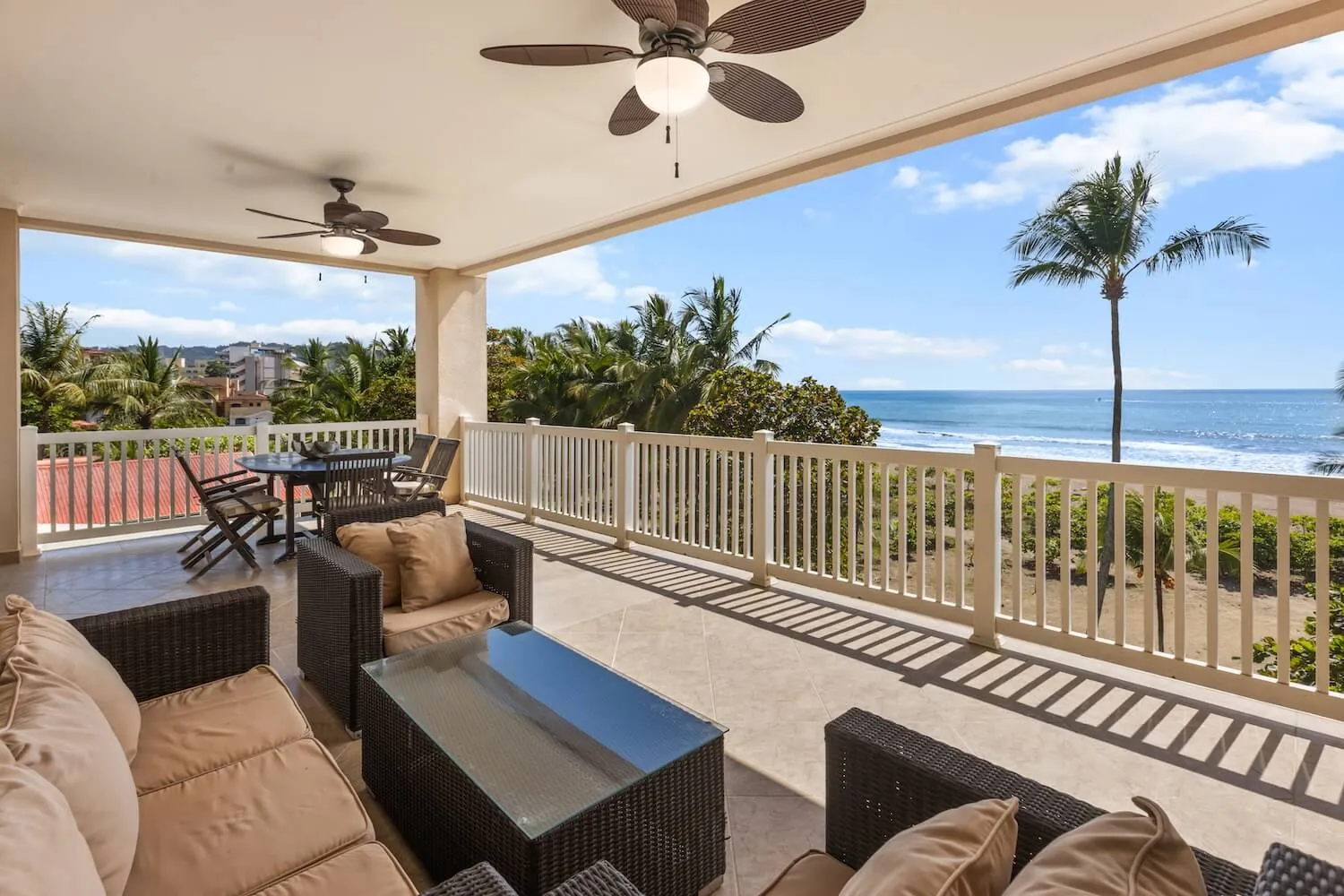 Wide covered balcony at The Palms 404 with sofas and a view of the ocean