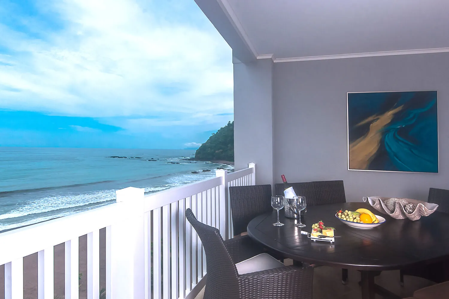 Breakfast table set on a balcony above Jaco Beach at The Palms