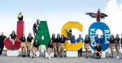 Jaco VIP Vacations staff team posing at the Jaco Beach welcome sign in Costa Rica